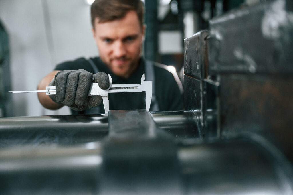 A close up of a worker using a tool for precision steel stamping