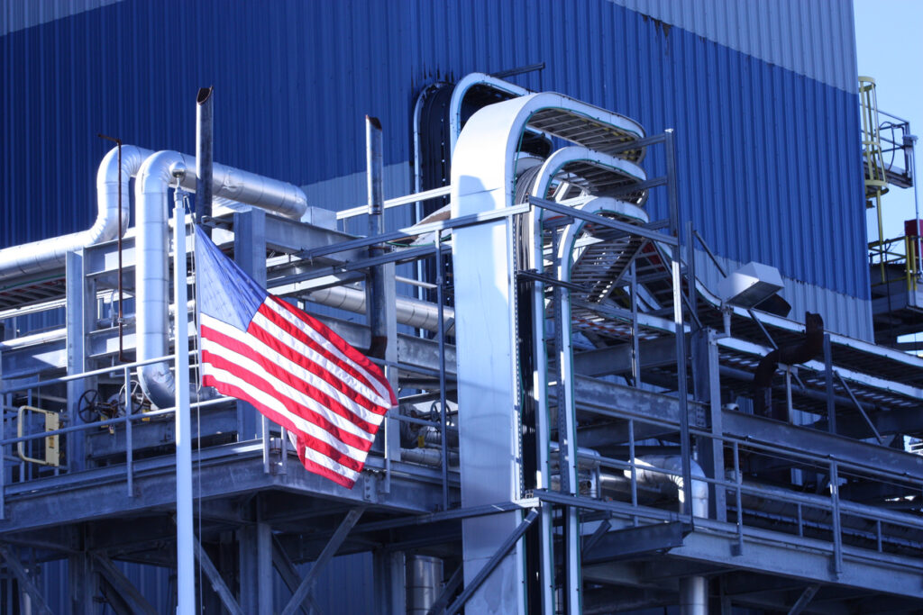 American flag at factory. Reshoring in metal stamping